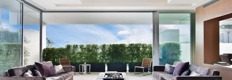 Moderne aluminium schuifpui met strak design en uitzicht op tuin.