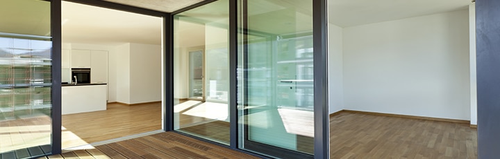 Moderne schuifpui met brede glaspanelen tussen woonkamer en tuin